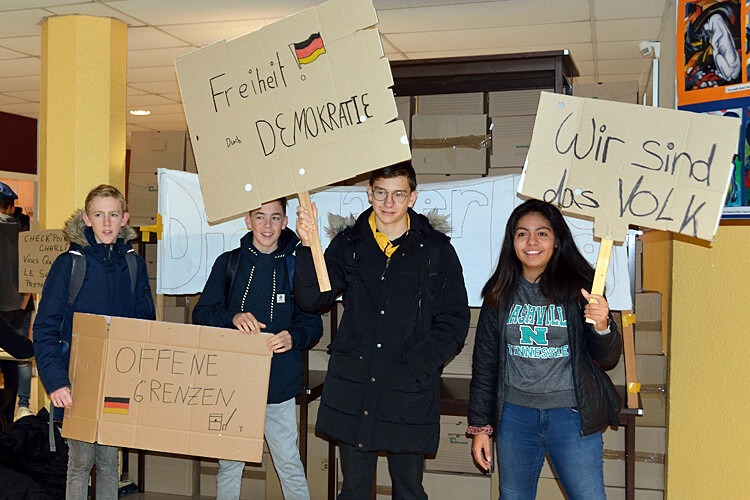 Mauerfall im Lycée: Schüler mit Demonstrationsplakaten