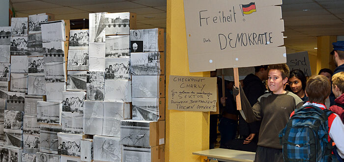 Mauerfall im Lycée: Schüler mit Demonstrationsplakat 