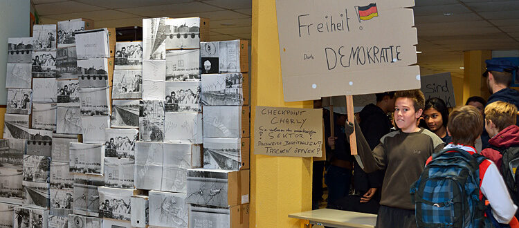 Mauerfall im Lycée: Schüler mit Demonstrationsplakat 