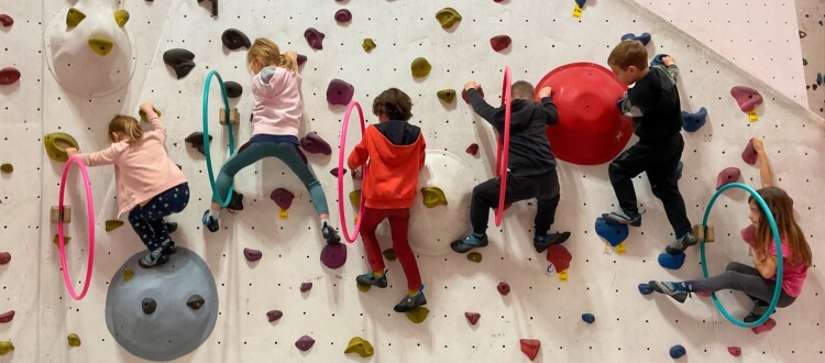 Deutsche Schule Toulouse, Kletterausflug, Kindergartenkinder klettern an einer Wand durch Reifen