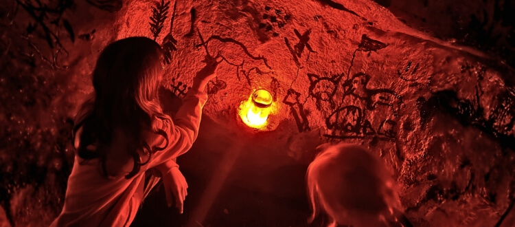 Zwei Kinder beim Höhlenmalen im Musée Préhistoire