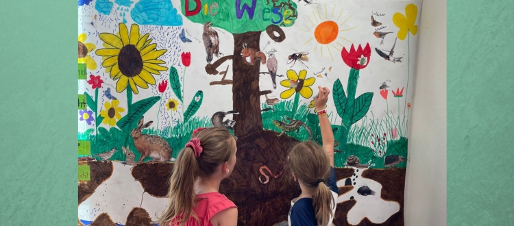 Deutsche Schule Toulouse : Kinder vor einem Infoplakat über Wiesen