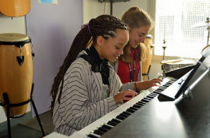 Zwei Schülerinnen spielen gemeinsam Klavier