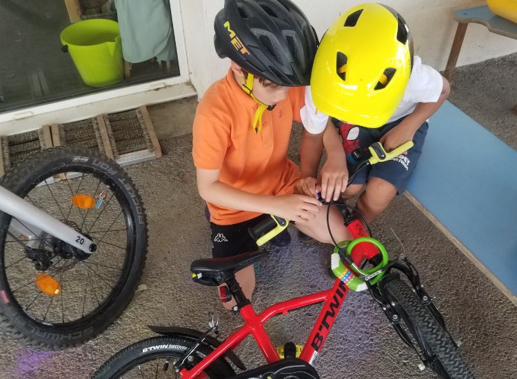 Zwei Kinder, die ein Fahrrad überprüfen