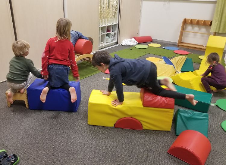 Kindergartenkinder klettern auf Schaumstoffelementen