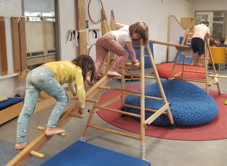 Kindergartenkinder klettern und balancieren auf Hengstenberg-Holzkonstruktionen