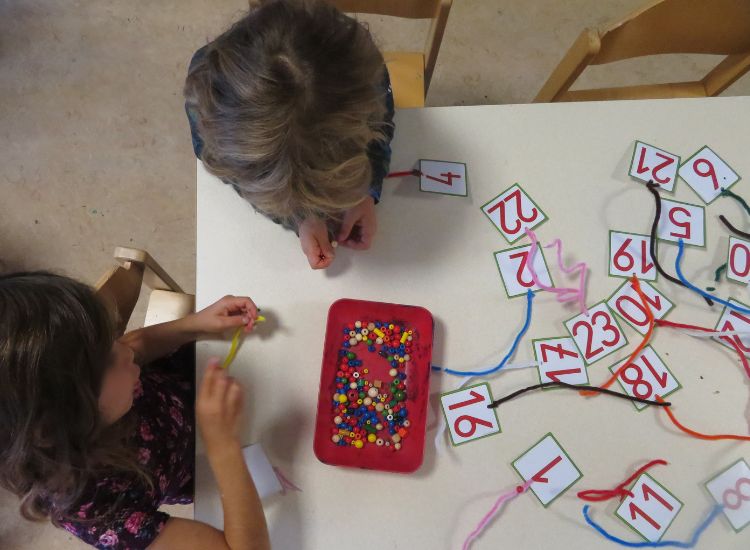 Kindergartenkinder beim Basteln mit Zahlenkarten