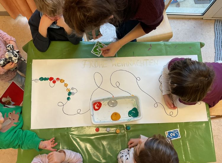 Kindergartenkinder legen Mengen mit Glasperlen auf eine Linie