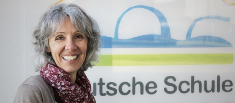Portraitbild Dagmar Schröteler vor dem Logo der Deutschen Schule Toulouse
