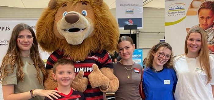 Deutsche Schule Toulouse: Mädchengruppe und Junge mit dem Maskottchen des Stade Toulousain