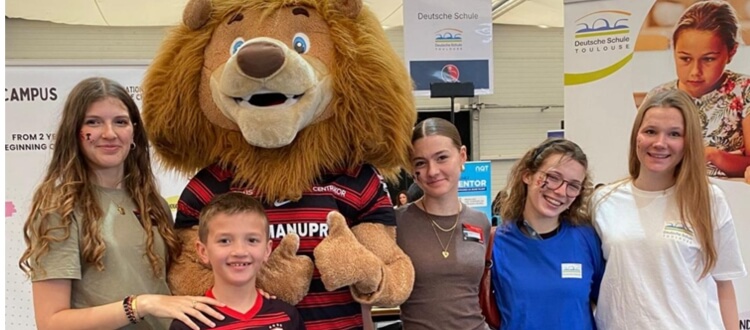 Deutsche Schule Toulouse: Mädchengruppe und Junge mit dem Maskottchen des Stade Toulousain